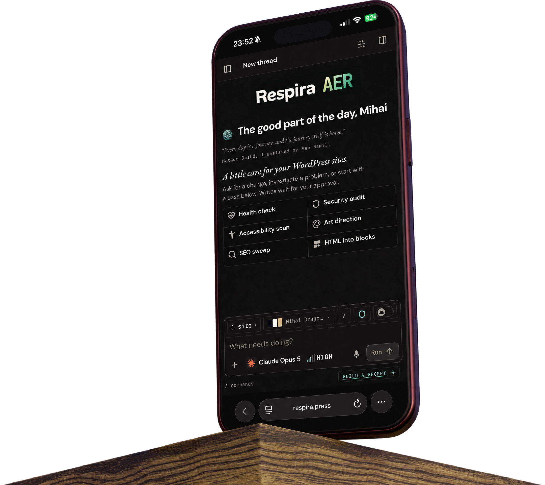 The real Respira AER homepage as seen on an iPhone 18 Pro Max in burgundy, standing on a wooden ledge.