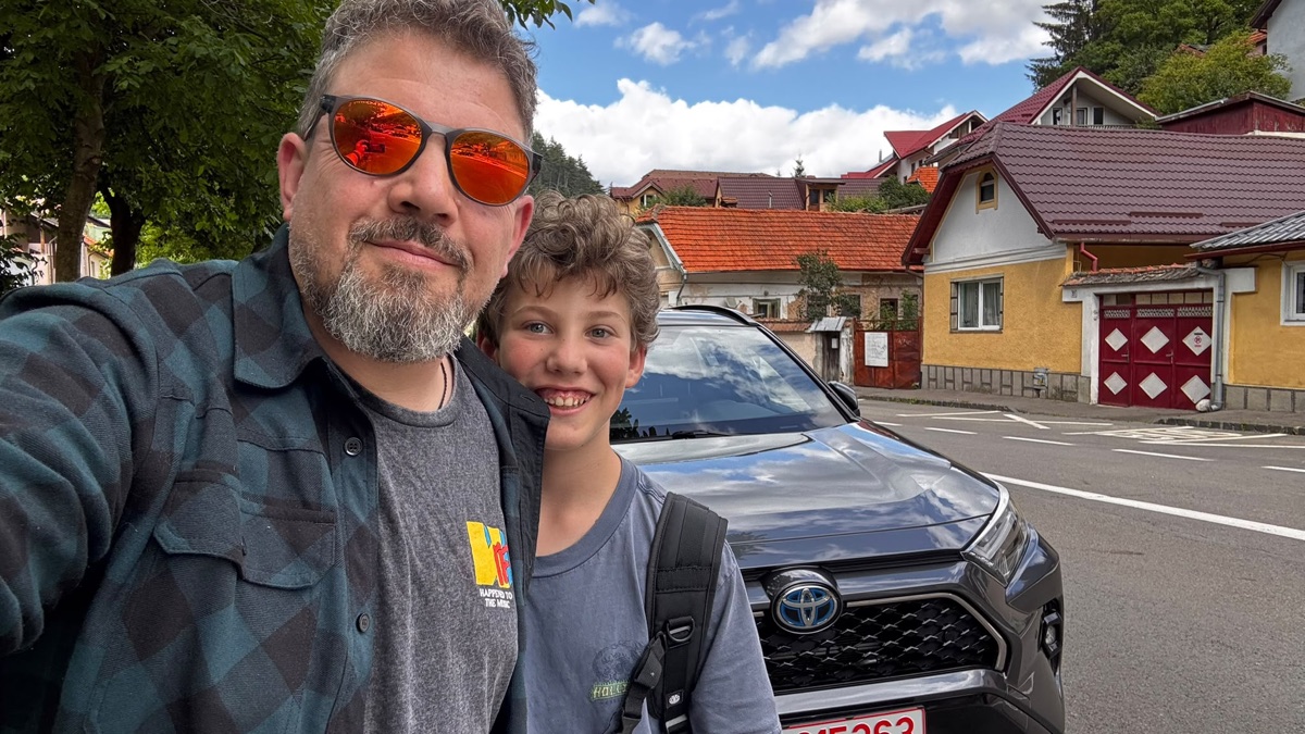 Mihai and his son standing beside the family car made possible by Respira