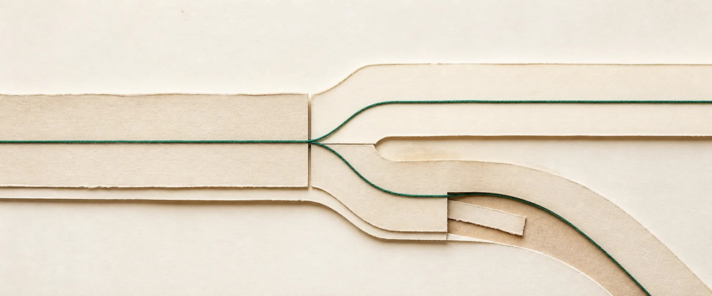 Two parallel paper paths: one closes a gap ahead while the other loops back to inspect an earlier layer.