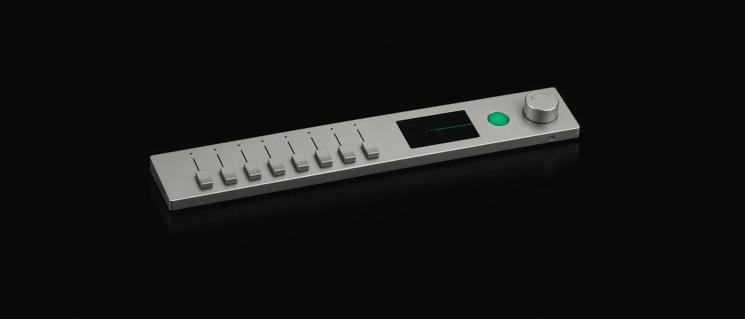 A slim aluminium mixer with eight price faders, a small screen tracing the new prices in emerald next to the old ones, an emerald confirm key and a knurled undo knob.