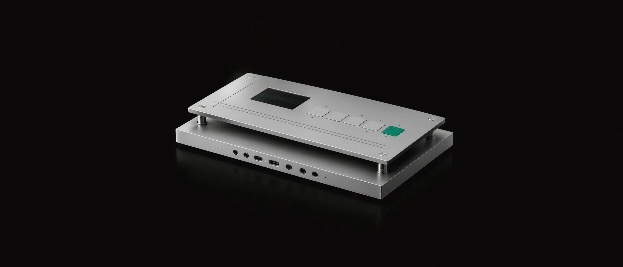 Two aluminium slabs stacked on short posts: a plain base with all its ports left open, and a slimmer layer resting above it with a screen, a few keys and one emerald key.